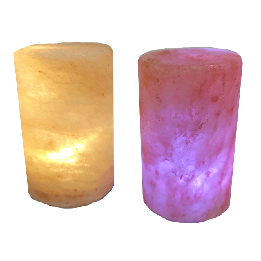 Two cylindrical Himalayan salt lamps lit from within, showing the pitted texture of the salt surface